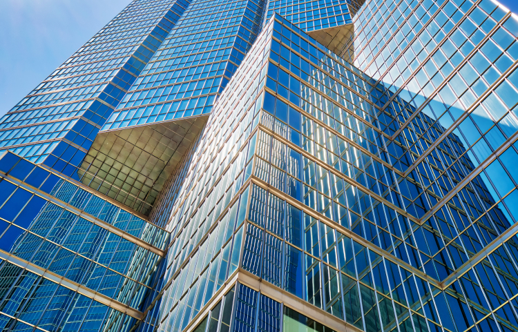 The sun reflecting off the side of a towering glass skyscraper
